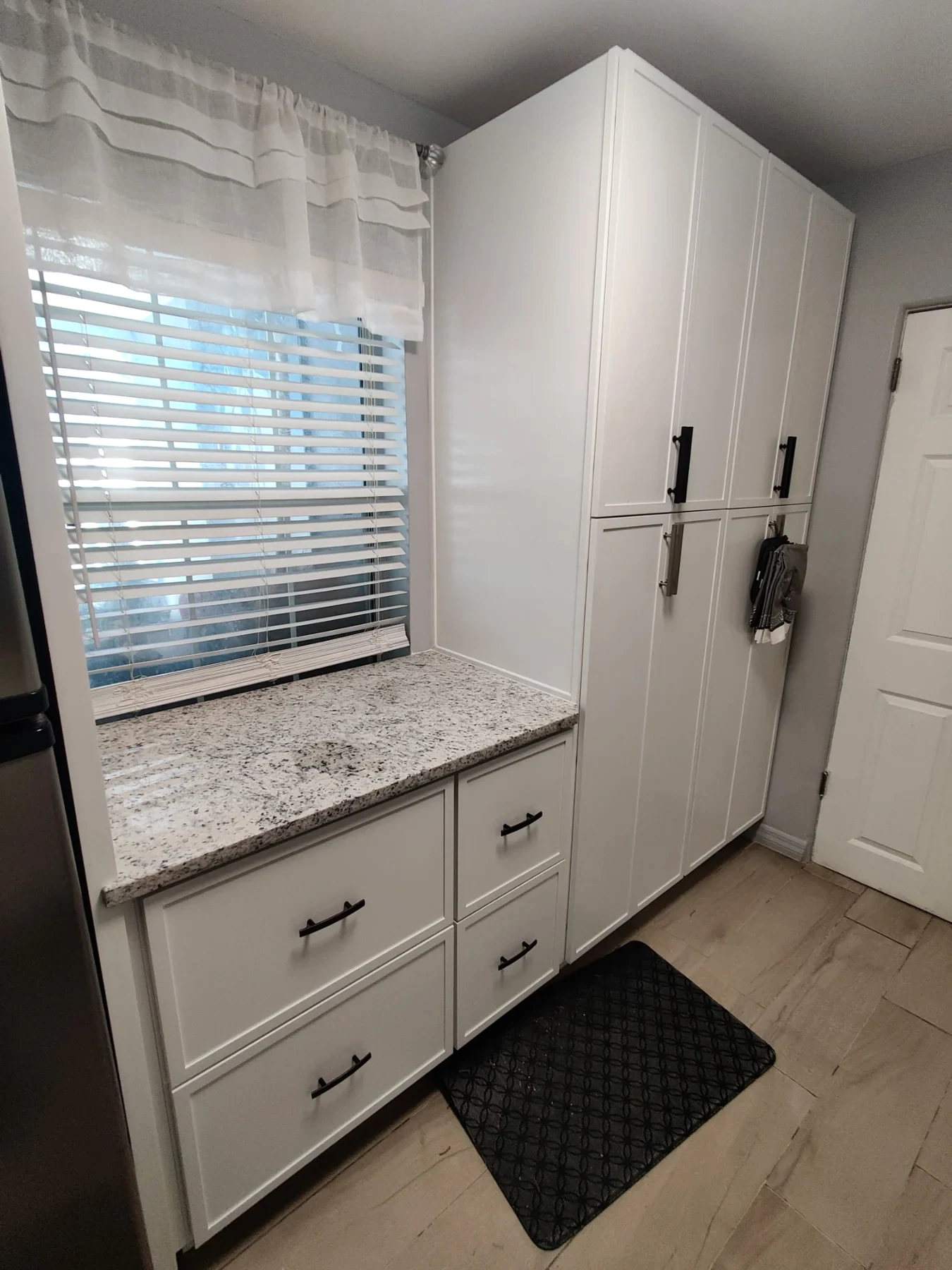 White bathroom vanity with countertop, mirror and adjacent shower