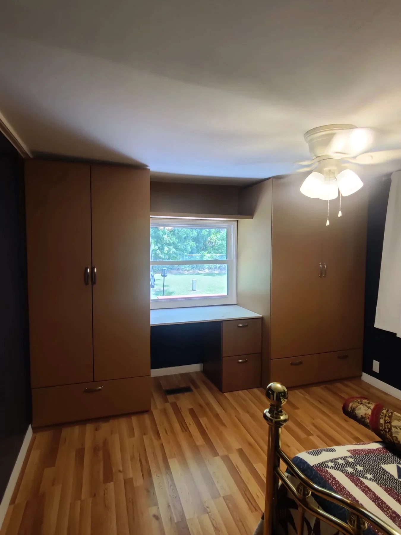 Tall storage cabinetry beside a bedroom window