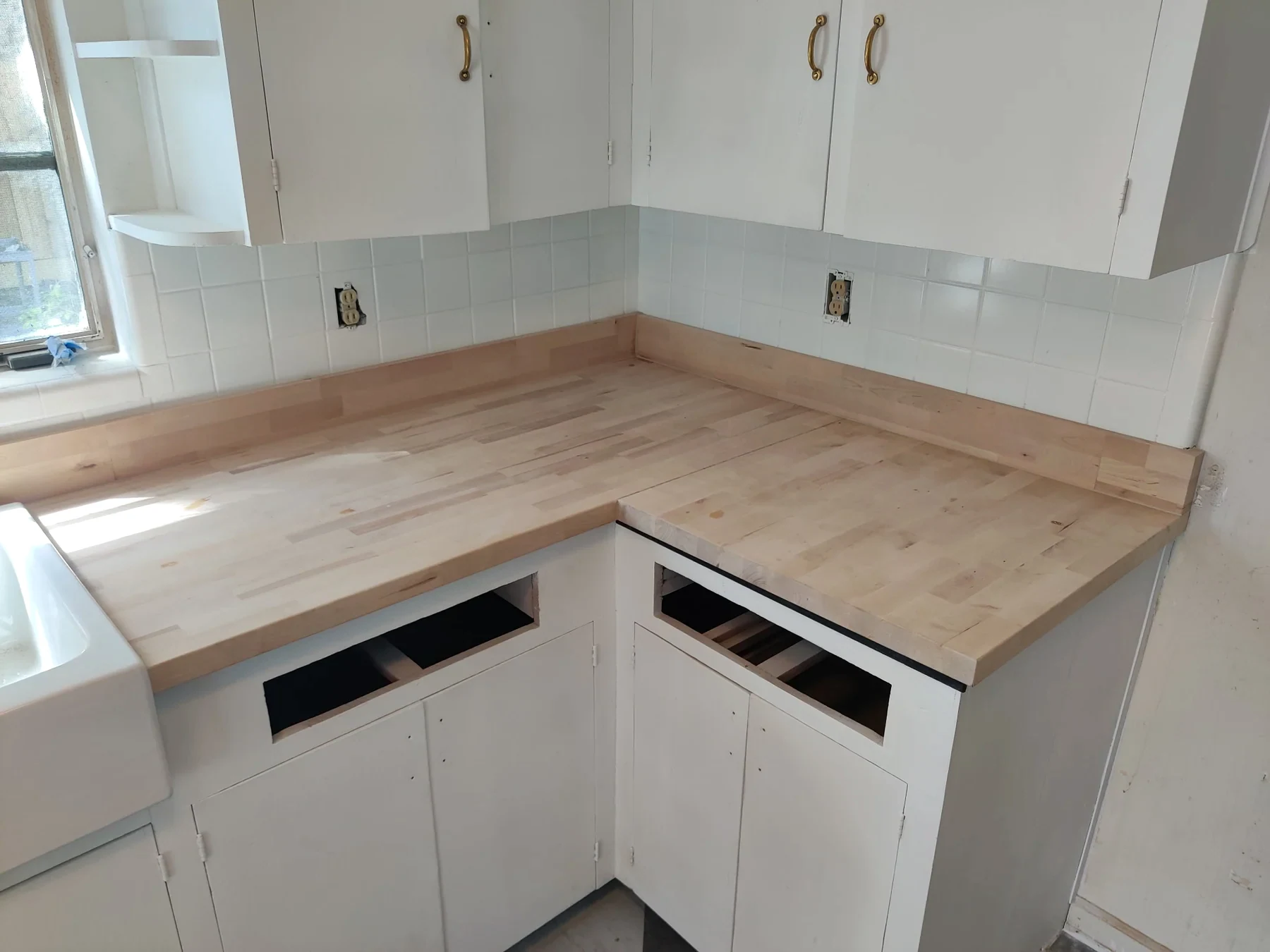 White kitchen cabinets meeting a light countertop at a corner