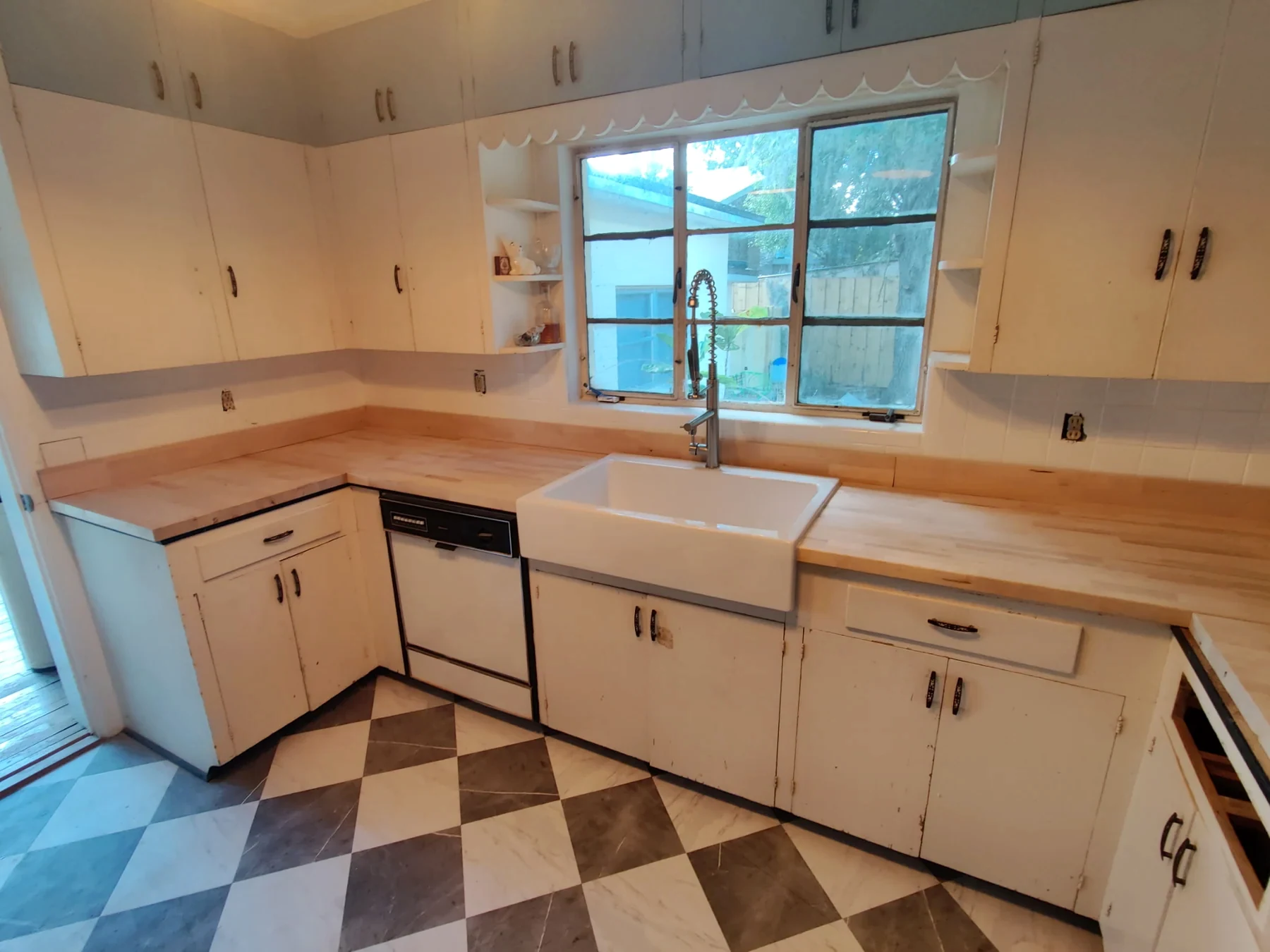 Finished kitchen with white cabinets, wood countertops and a patterned tile floor